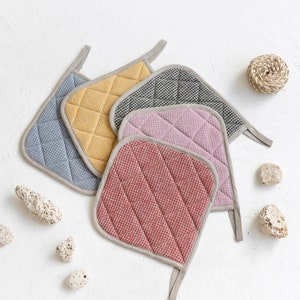 May include: Set of five quilted pot holders in various colours, including red, pink, yellow, blue, and black. The pot holders have a checkered pattern and are made of a soft, textured fabric.