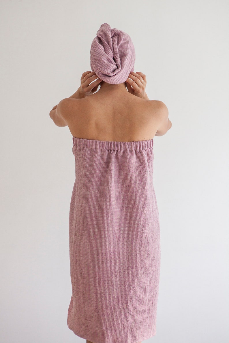 Pu&ograve; includere: Un accappatoio rosa in spugna a nido d'ape con stile avvolgente e cintura con coulisse.