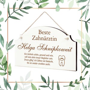 May include: A white wooden sign with brown text that reads "Beste Zahnärztin Helga Schnipkoweit". The sign also includes a small smiling tooth graphic and a poem about taking care of your teeth.