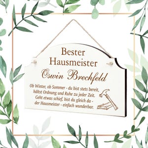 Könnte beinhalten: Ein weißes Holzschild mit braunem Text, auf dem "Bester Hausmeister Oswin Brechfeld" steht. Das Schild enthält auch ein kurzes Gedicht über einen Hausmeister, der immer zur Stelle ist.
