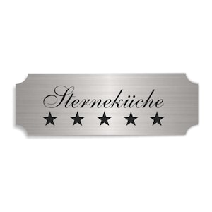 Peut inclure: Une plaque en métal argenté avec le texte "Sternekueche" et cinq étoiles noires.