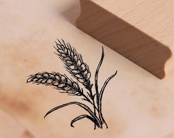 May include: A black and white illustration of wheat stalks on a wooden background. The image is a rubber stamp.