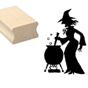 May include: A wooden rubber stamp featuring a black silhouette of a witch stirring a cauldron with a large, round, black cauldron.