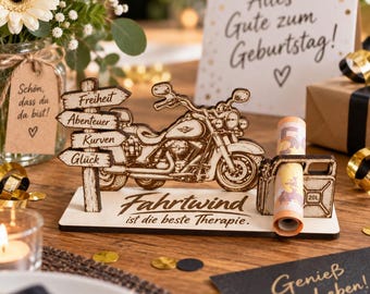 May include: A wooden decorative display featuring a laser-cut motorcycle and a signpost with the words Freiheit, Abenteuer, Kurven, and Glück. The base includes the text Fahrtwind ist die beste Therapie and a holder containing a rolled banknote.