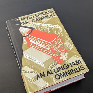 Puede incluir: Una portada de libro con un diseño rojo y dorado. El título es "The Mysterious Mr. Campion: An Allingham Omnibus". La portada presenta un autobús de dos pisos rojo con el texto "The Tiger in the Smoke" y "Full 3 Novels".