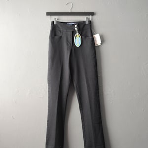 May include: Black high-waisted jeans with a button fly and a small blue tag that says "Leg Avenue".