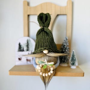 Gebreide kerstkabouter met krans: gelaagd bladdecor