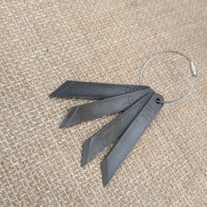 May include: Five black metal blades with a silver key ring. The blades are labeled with the numbers 1, 2, 3, 4, and 5.