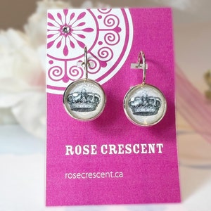 Earrings feature a crown pen and ink drawing under glass in silver plated setting with lever back for pierced ears.