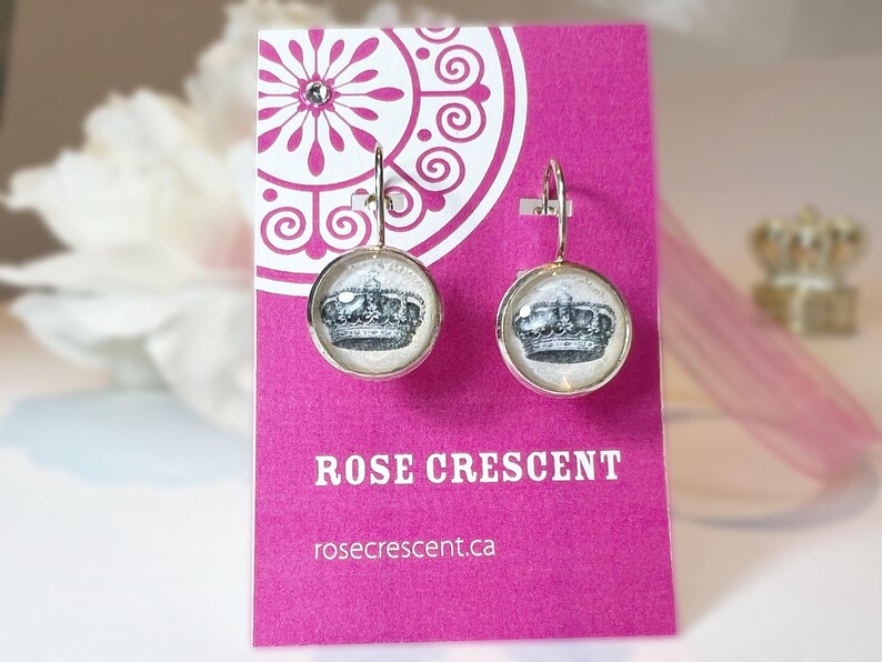 Earrings feature a crown pen and ink drawing under glass in silver plated setting with lever back for pierced ears.