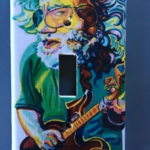 May include: A light switch cover featuring a colorful, psychedelic portrait of a man with a long beard playing a guitar. The background is a swirling mix of blue, green, and yellow.