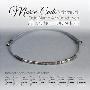 Könnte beinhalten: Ein graues Armband aus Schnur mit silbernen Perlen, die eine Botschaft in Morsecode buchstabieren. Das Armband befindet sich auf einem grauen Hintergrund mit dem Text "Morse-Code Schmuck" und "Dein Name & Wunschwort als Geheimbotschaft". Unter dem Armband befindet sich eine Tabelle des internationalen Morse-Alphabets.
