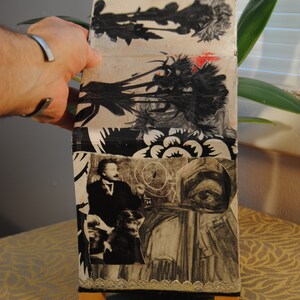 May include: A small, wooden box with a collage of black and white images and a floral pattern. The box has a silver trim and sits on a brown patterned surface.