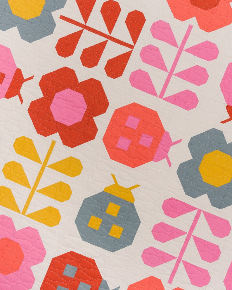 Puede incluir: Una colcha de retazos con un dise&ntilde;o geom&eacute;trico que presenta mariquitas, flores y hojas en tonos rojos, rosas, amarillos y azules.