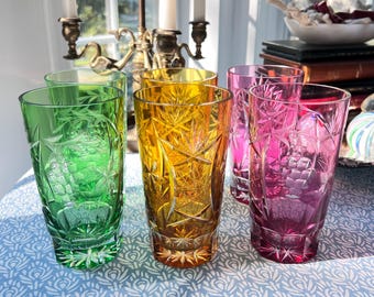 May include: Set of six cut glass tumblers in green, amber, and pink. The glasses have a geometric pattern and are perfect for serving water, juice, or cocktails.