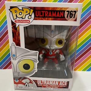 以下が含まれることがあります： オリジナルパッケージに入った、Funko Pop!のウルトラマンエースのビニールフィギュア、ナンバー767。フィギュアは赤、銀、黄色です。箱にはPop! Televisionのロゴとウルトラマンエースの名前が記載されています。