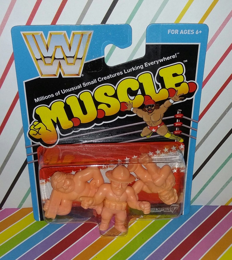May include: A package of three small, orange, plastic wrestling figures. The figures are in a clear plastic blister pack. The package is labeled "WWE Muscle" and features a wrestler in a red and yellow outfit in a wrestling ring. The package is for ages 6 and up.