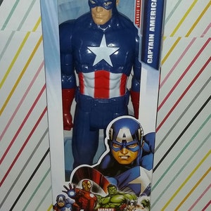 May include: Captain America action figure in a clear plastic package. The figure is blue with a white star on the chest and red and white stripes on the torso. The packaging reads "Avengers Assemble Titan Hero Series."
