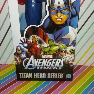 May include: A blue and red Captain America action figure in its packaging. The box features Captain America, Iron Man, Hulk, and other Avengers characters. The text "Avengers Assemble" and "Titan Hero Series" are visible.