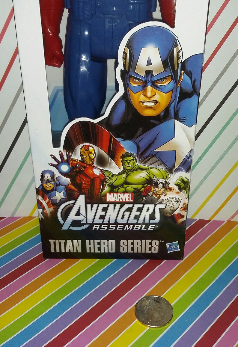 May include: A blue and red Captain America action figure in its packaging. The box features Captain America, Iron Man, Hulk, and other Avengers characters. The text "Avengers Assemble" and "Titan Hero Series" are visible.