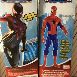 May include: Two action figures of Spider-Man, one in a red and blue suit and the other in a red and black suit. Both figures are posed in a dynamic action pose. The packaging features the Marvel logo and the text "Ultimate Spider-Man".
