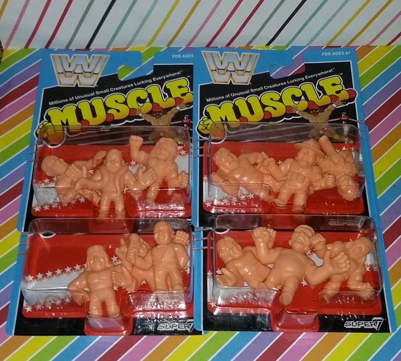 May include: A package of four sets of small, orange, plastic wrestling figures. Each set contains four figures. The packaging is red and white with the words "Millions of Unusual Small Creatures Lurking Everywhere!" and "MUSCLE" in black and white. The packaging also features the WWF logo.