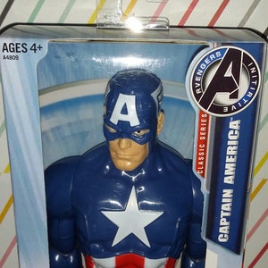 May include: Captain America action figure in a box. The figure is primarily blue with a white star on the chest and red and white stripes on the lower torso. The packaging includes the text "Captain America" and "Avengers Initiative".