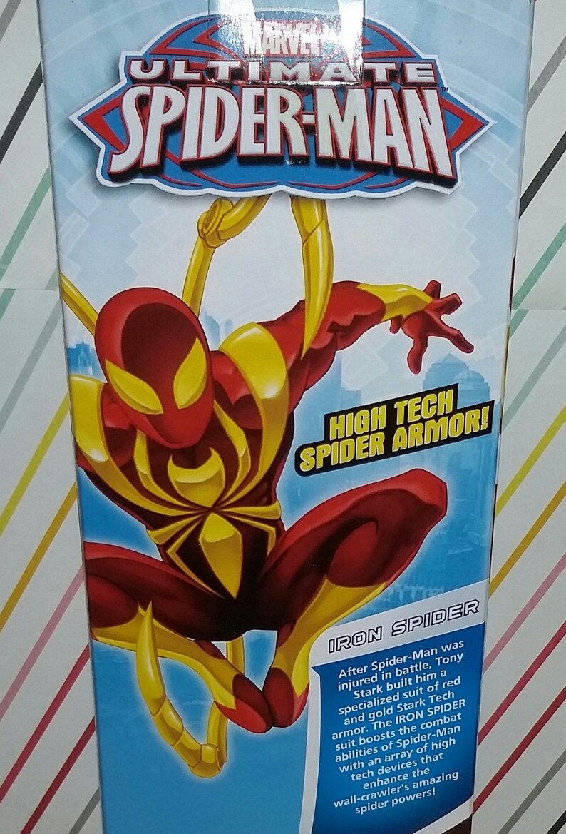 May include: A red and gold action figure of Iron Spider from the Ultimate Spider-Man series. The figure is posed in a dynamic action pose with its arms outstretched. The figure is wearing a high-tech suit with a spider symbol on the chest. The text on the box reads "High Tech Spider Armor!" and "Iron Spider".