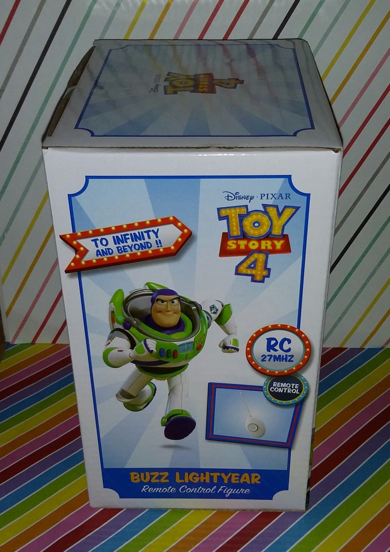 K&ouml;nnte beinhalten: Verpackung der Buzz Lightyear Fernbedienungsfigur aus Toy Story 4. Die Schachtel zeigt ein Cartoon-Bild von Buzz Lightyear in seinem Weltraum-Ranger-Anzug, der mit ausgestreckten Armen rennt. Die Schachtel ist wei&szlig; mit blauen und roten Akzenten. Der Text auf der Schachtel lautet "To Infinity and Beyond!" und "RC 27MHz Remote Control".