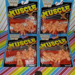 May include: Four packages of WWF Muscle collectible figures. Each package features a wrestling ring with three wrestlers in various poses. The wrestlers are made of a soft, flexible plastic and are painted in bright colors. The packages are blue and red with the words "WWF Muscle" printed in large, white letters.