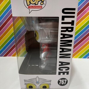 以下が含まれることがあります： ウルトラマンエースのFunko Pop! Televisionボックス。白い箱にはPop! Televisionのロゴと黒字で「ULTRAMAN ACE」の文字が入っています。フィギュアは透明なプラスチックの窓から見えます。