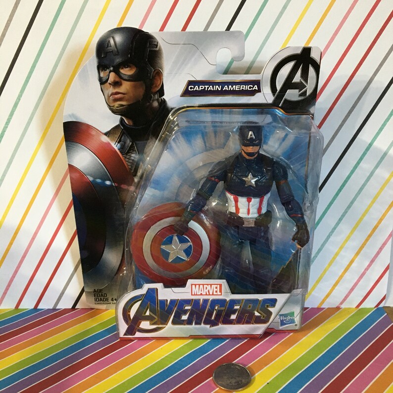 May include: A plastic action figure of Captain America from the Marvel Avengers movie series. The figure is holding a red, white, and blue shield and is wearing a blue and red costume with a star on the chest. The figure is packaged in a plastic blister pack with a blue and white background. The packaging features the Marvel Avengers logo and the words "Captain America".