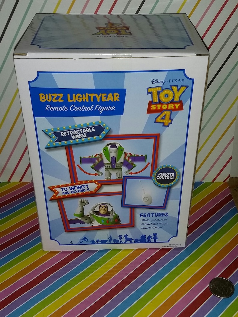 K&ouml;nnte beinhalten: Eine wei&szlig;e Box mit einem farbenfrohen Toy Story 4 Design. Die Box zeigt Buzz Lightyear, einen Weltraum-Ranger, mit einziehbaren Fl&uuml;geln. Auf der Box steht "Buzz Lightyear Fernbedienungsfigur" und "Bis ins Unendliche und dar&uuml;ber hinaus!" Die Box zeigt auch "Eigenschaften: Vorw&auml;rts gehen, Einziehbare Fl&uuml;gel, Fernbedienung".