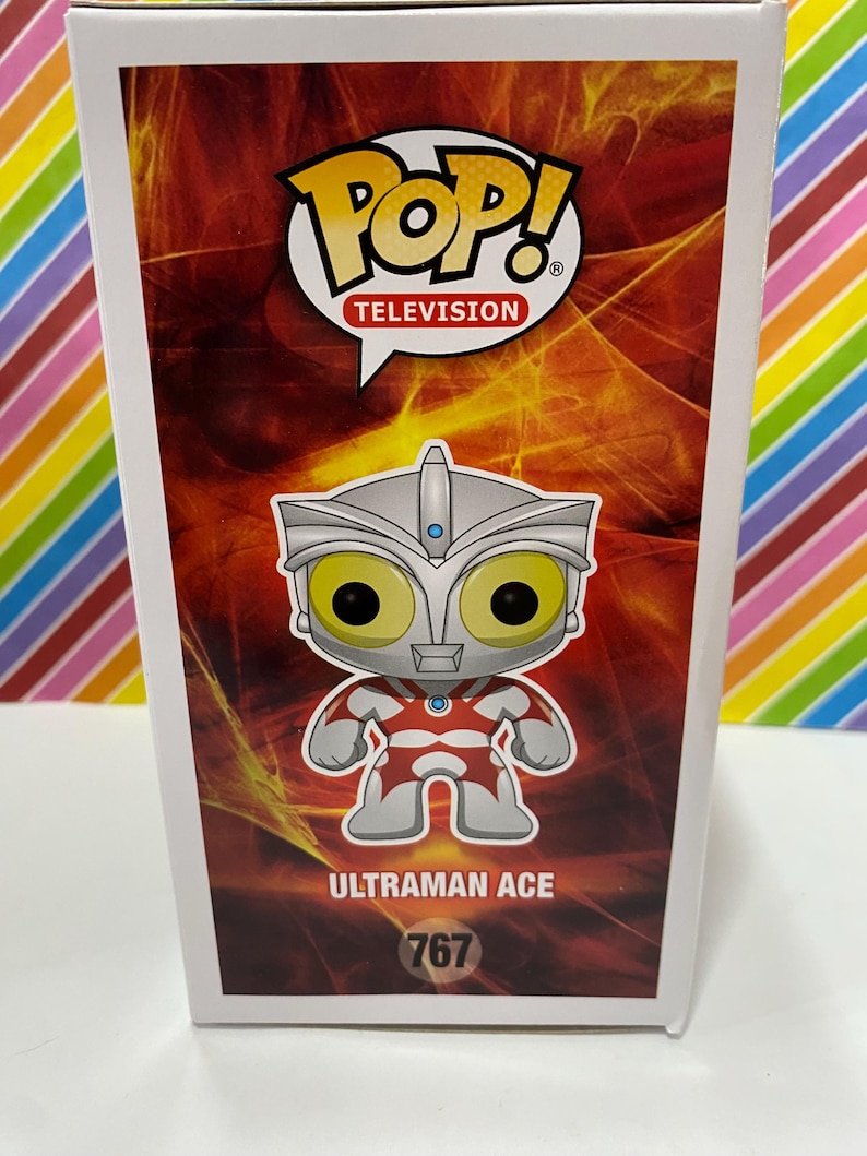 以下が含まれることがあります： ウルトラマンエースのFunko Pop! Televisionボックス。ボックスは赤と白の配色で、キャラクターの画像が大きく表示されています。Pop!のロゴが上部にあり、番号767が下部にあります。
