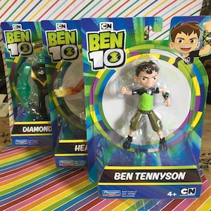 May include: Three Ben 10 action figures in their original packaging. The figures include Diamond, Heatblast, and Ben Tennyson. The packaging features the Ben 10 logo and character illustrations. The figures are designed for ages 4 and up.