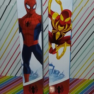 May include: Two cardboard boxes with images of Spider-Man on them. The boxes are red, blue, and yellow. The text on the boxes reads "MARVEL ULTIMATE SPIDER-MAN" and "TITAN HERO SERIES".