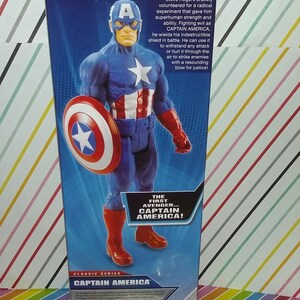 May include: A Captain America action figure in a blue, red, and white costume, holding a shield. The packaging features the Marvel Avengers Assemble logo and text that reads "The First Avenger... Captain America!"
