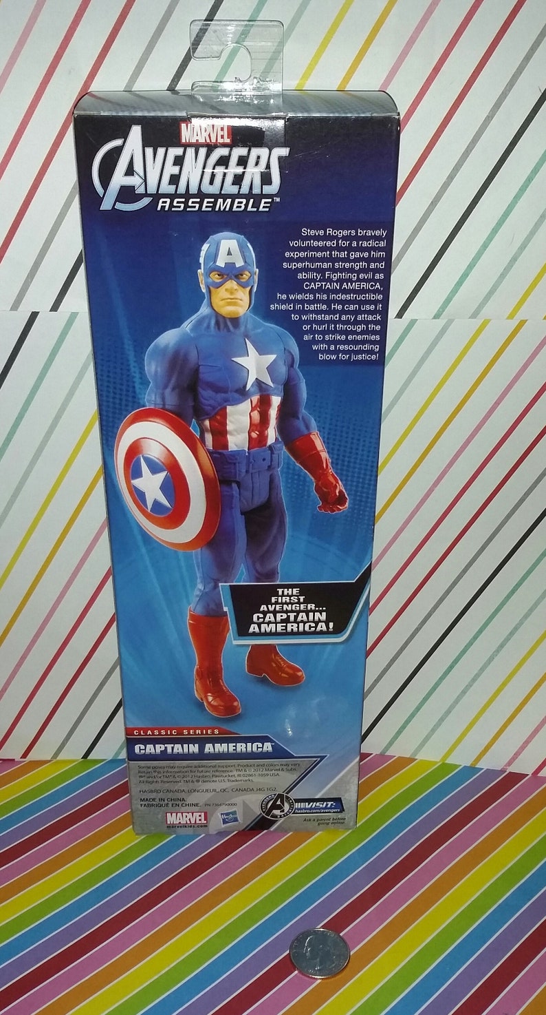 May include: A Captain America action figure in a blue, red, and white costume, holding a shield. The packaging features the Marvel Avengers Assemble logo and text that reads "The First Avenger... Captain America!"