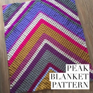 May include: A colorful crochet blanket with a chevron pattern in shades of purple, pink, white, gold, and gray. The blanket is made with a textured stitch that creates a raised, bumpy surface. The text "PEAK BLANKET PATTERN" is printed in black on a white background in the lower right corner of the image.