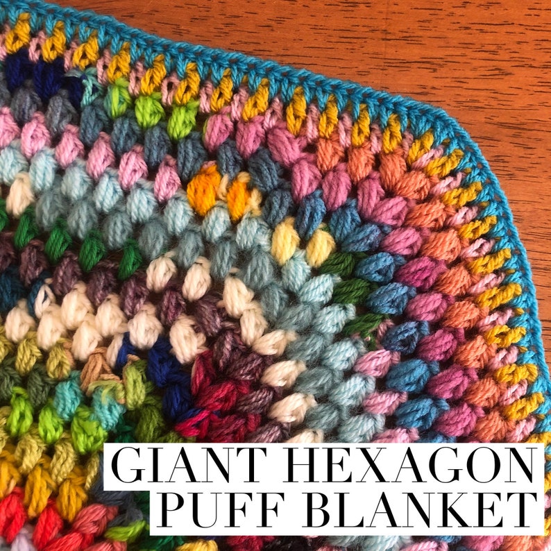 May include: A colorful crochet blanket with a giant hexagon puff stitch pattern. The blanket is made with a variety of colors, including blue, green, pink, yellow, and white.