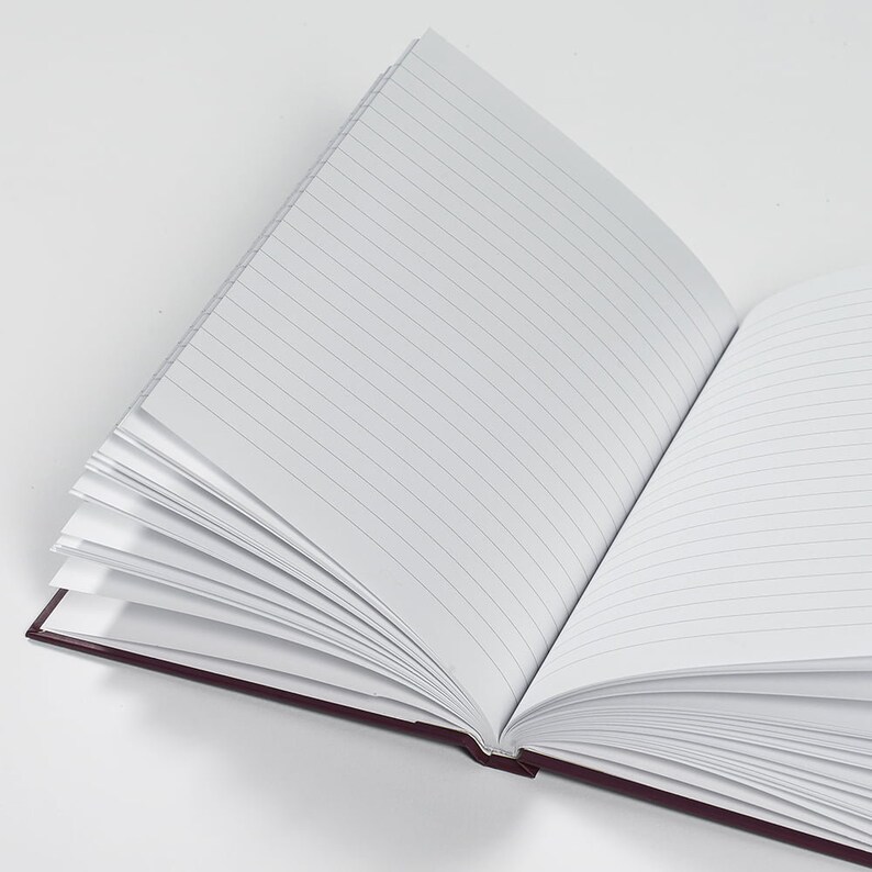 Pu&ograve; includere: Un quaderno aperto con copertina color borgogna e pagine a righe. Le pagine sono vuote e pronte per essere scritte.