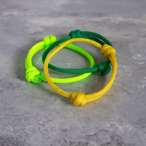 stack of adjustable paracord bracelets, in dark yellow, green and neon green