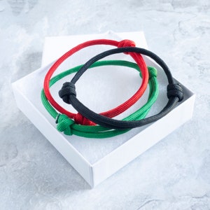 A set of paracord bracelets in black, red and green.