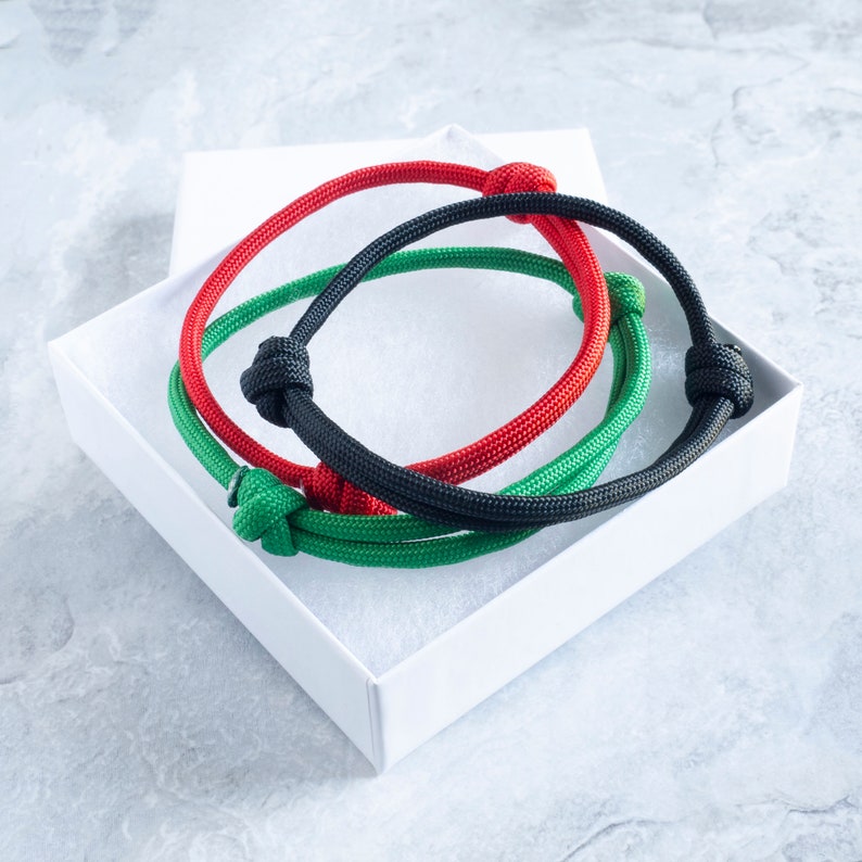 A set of paracord bracelets in black, red and green.