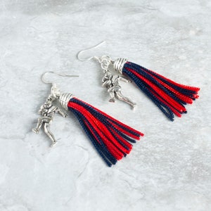 red and black tassel earrings with silver football player charms