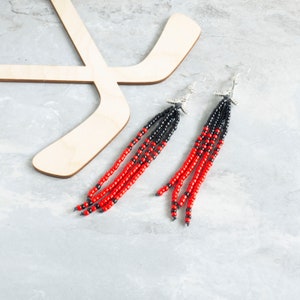 Long beaded tassels hanging from hockey charm earrings