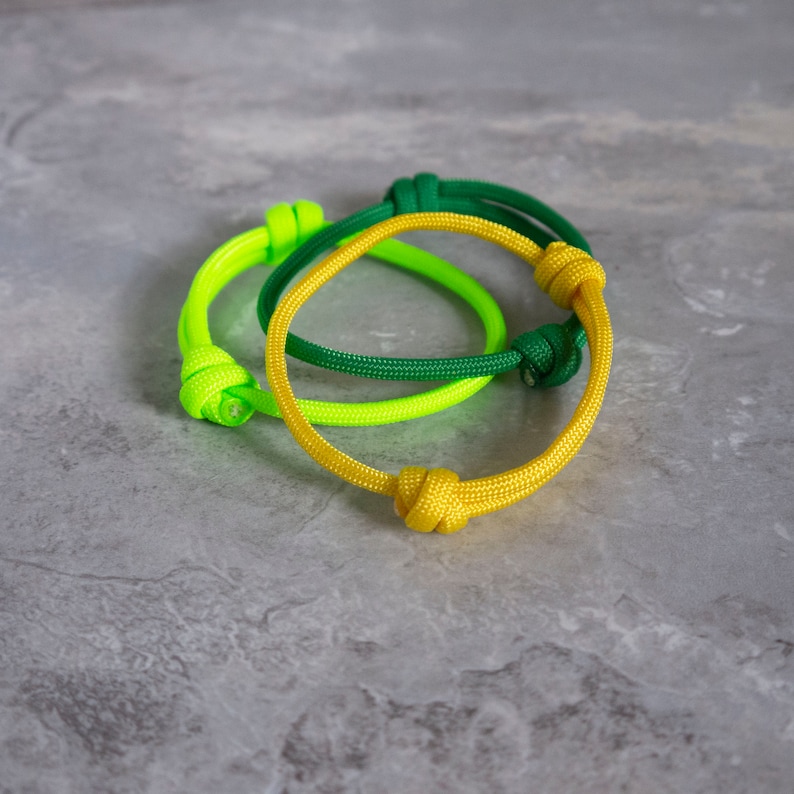 stack of adjustable paracord bracelets, in dark yellow, green and neon green