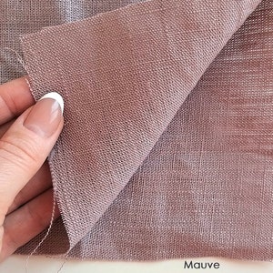 Puede incluir: Un primer plano de una tela de lino de color malva. La tela tiene un tejido texturizado y est&aacute; doblada por la mitad. La palabra "Malva" est&aacute; impresa en blanco en la parte inferior de la imagen.