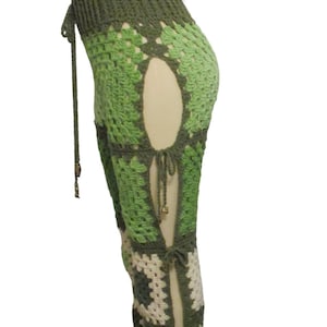 May include: Crocheted green and off-white pants with open side panels and tie closures. The pants are displayed on a mannequin. The text "Valli's Crochet Boutique" is visible in the image.