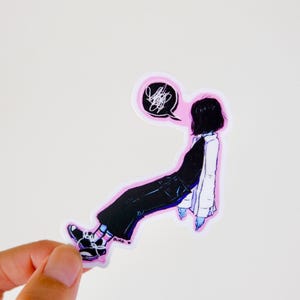 May include: A die-cut vinyl sticker featuring an illustration of a person with short black hair wearing a black top, dark pants, and a white jacket. The figure is depicted with a speech bubble containing a black scribble and has a pink border.